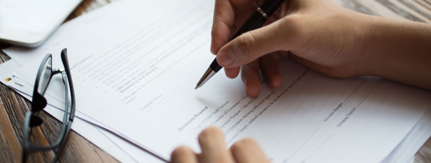 table with insurance papers being signed